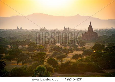 Beautiful ancient pagoda field in sun rise with fog and haze
