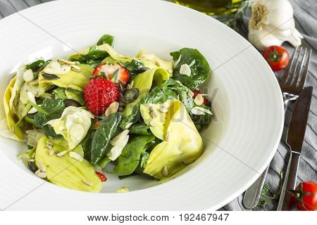 Salad with spinach avocado iceberg lettuce and strawberry.