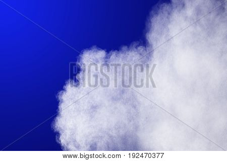 Abstract White powder explosion on blue background.