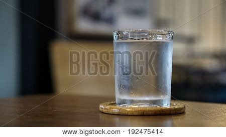 A glass of water on wood table.