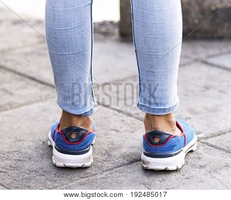 Girl stand blue jean and blue shoe