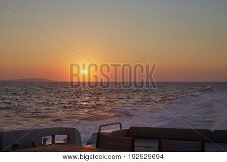 Yacht sailing passing by beautiful sunrise. Fresh and sailty air is all around. Warm colors. Sailboat. Yachting. Travel Concept. Vacation