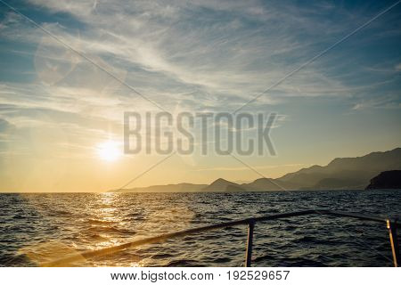 Coast of Montenegro at sunset, view from the sea, silhouettes of mountains