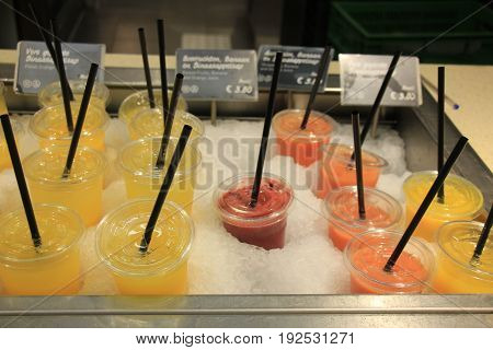 Fresh fruit smoothies at a self service counter at a restaurant (text on tags: price and product information in Dutch)