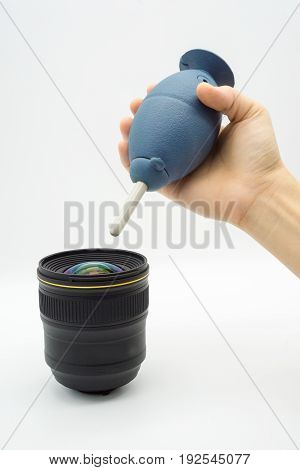 Hands holding a rubber air blower pump dust cleaner and len isolated on white background
