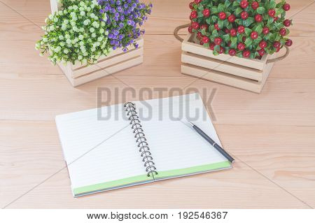 Spiral notebook with flowers on wood background