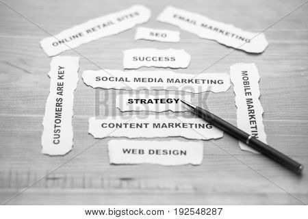 B/W focusing of strategy paper rip with soft style on wood background