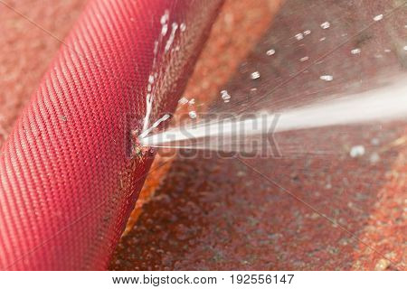 water leaking from hole in a hose.