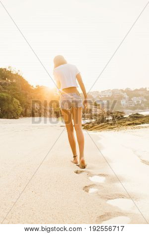 Girl In Shorts Walk On The Beach.