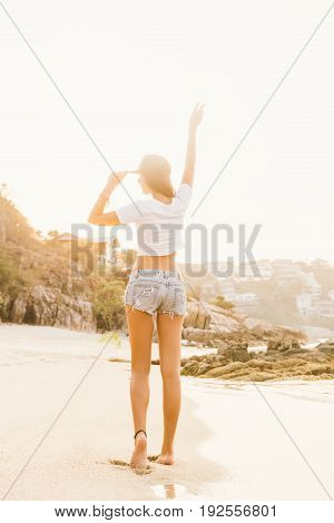 Girl In Shorts Walk On The Beach.