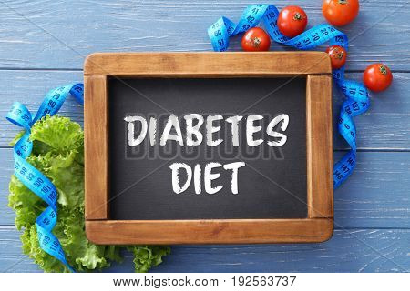 Small chalkboard with text DIABETES DIET and healthy food on wooden background. Health care concept