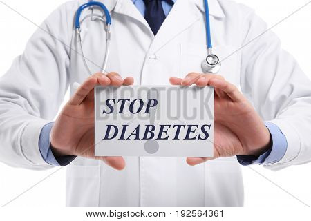 Health care concept. Doctor holding paper with text STOP DIABETES on white background