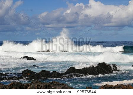 a wave splashing on the volcanic rock