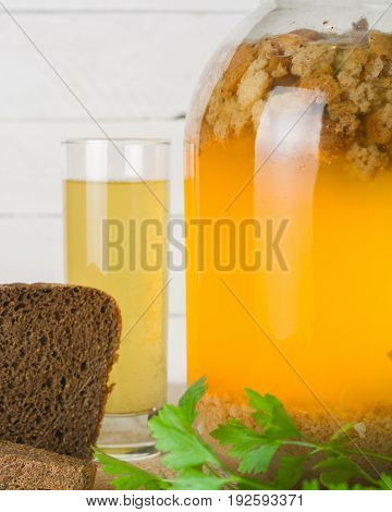 A Large Jar With Kvass Cooking. Black Bread And A Glass With A Drink.