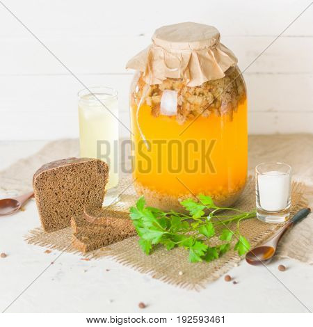 A Large Jar With Kvass Cooking. Black Bread And A Glass With A Drink.