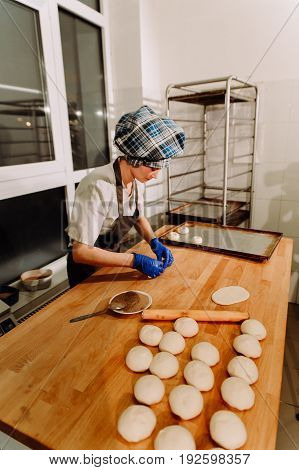 Making cinnamon buns. Homemade raw yeast dough after raising ready to bake, a Baker making cinnamon rolls