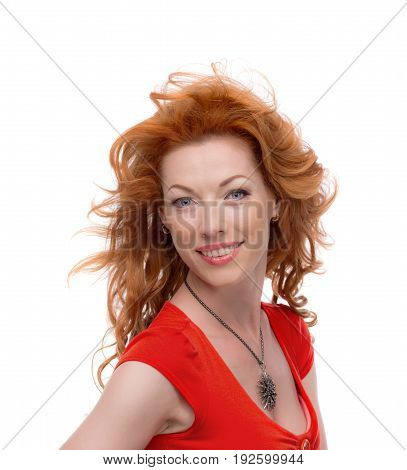 Redhead in a red dress standing sideways and smiling.