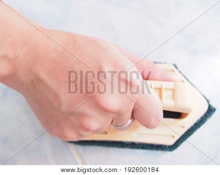 Cleaning on tile wall by Scotch-brite, holder