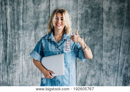 Lovely pretty girl with a laptop smiling and happy that she did the work on time