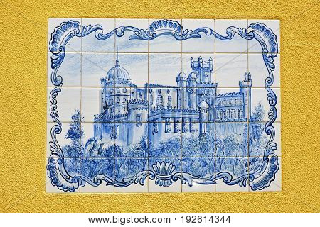 Sintra Portugal - June 03 2017: Blue azulejo panel of tiles in yellow plastered wall Sintra with the Pena National Palace