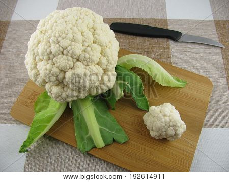 Cleaned fresh white cauliflower on a wooden board