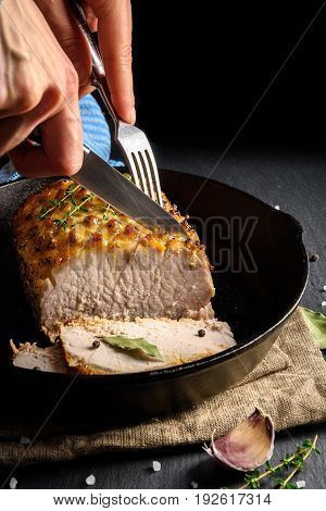Roasted and sliced pork carbonade glazed with honey and mustard on black iron pan
