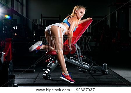 Fitness Young Sweaty Girl With A Sports Body In The Gym Sexually Performs Exercises With Dumbbells O