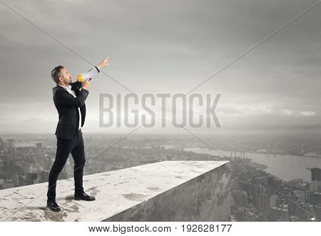 Businessman authoritarian announcement to the megaphone from above a roof