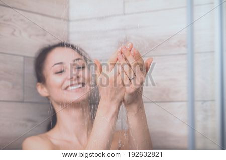 Young beautyful woman under shower in bathroom.