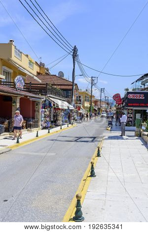 SIDARI, GREECE - MAY 24: View of a typical colorful street in a seaside town full of tourists on a sunny day on May 24, 2017 in Sidari, Corfu island in Greece.