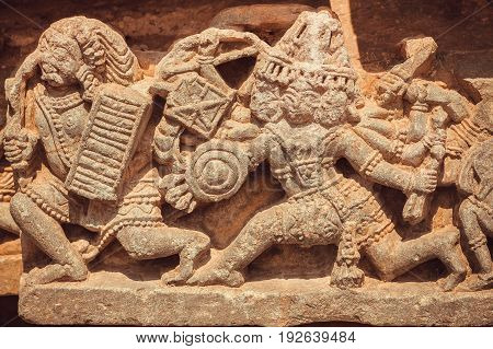 Scene with battles of ancient gods on stone sculptures of decoration inside the Hindu temple. Walls with artworks and designed patterns of 12th centur Hoysaleshwara temple in Halebidu, India