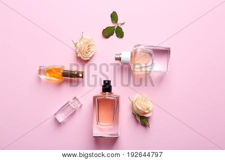 Perfume bottles on pink background, top view