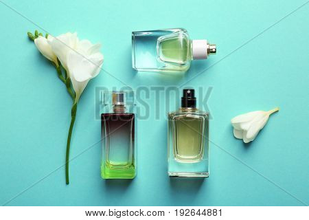 Perfume bottles on mint background, top view