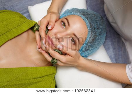 Spa treatment. Facial massage with jade stones. Alternative medicine. Massage cheeks zone. Guasha