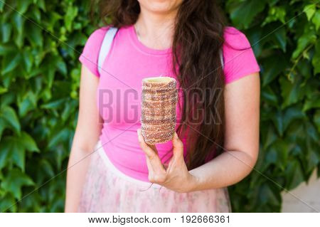Close-up of young female tourist with traditional czech dessert trdelnik in Prague. Czech Republic. Outdoor.
