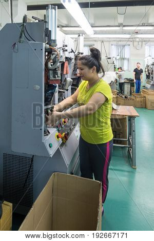 MOSCOW, RUSSIA - FEBRUARY 21, 2017: Moscow shoe factory JSC RALF RINGER. A female worker is working on a shoe forming machine.