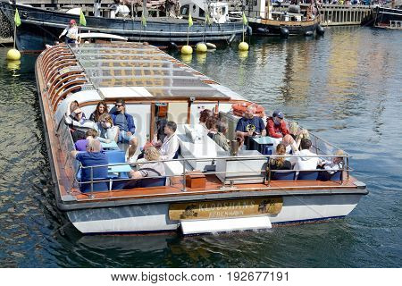NYHAVN, COPENHAGEN - JULY 12, 2016: A guided tour on a small boat around Nyhavn waterway sites, Nyhavn, Copenhagen, Denmark