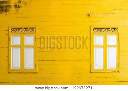 yellow peeling painted on wooden wall with white window textures background cracked paint