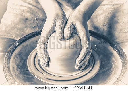 Girl sculpts in clay pot closeup. Modeling clay close-up. Caucasian man making vessel daytime of white clay in fast moving circle. Art, creativity. Ukraine, cultural traditions. Hobbies