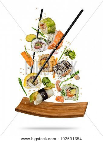 Sushi pieces placed between chopsticks, separated on white background. Popular sushi food.