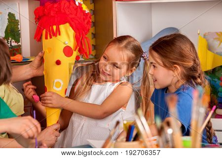 Small students painting in art school class. Child drawing by paints on table. Girl make candy cone schultuete in kindergarten for school. Drawing education develops creative abilities of children.