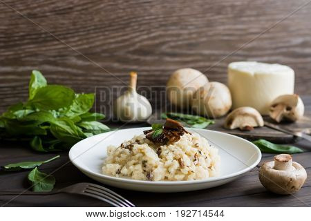 Risotto With Mushrooms On A Dark Wooden Background