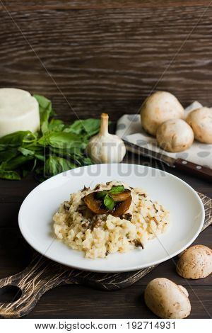 Risotto With Mushrooms On A Dark Wooden Background