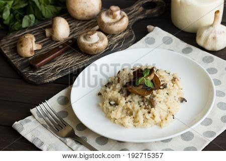 Risotto With Mushrooms On A Dark Wooden Background