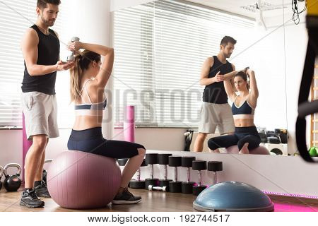 Personal trainer working on well eqiupped gym