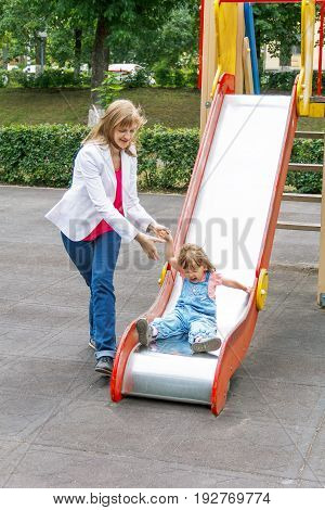 Mother with baby girl riding on hutches with screw up one eyes