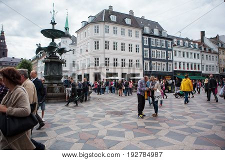 Copenhagen Denmark - July 29 2015: Tourists and locals walk in Amagertorv the most central square in central Copenhagen Denmark.