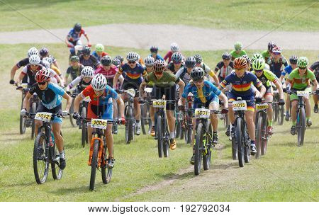 STOCKHOLM SWEDEN - JUNE 11 2017: Large group of fighting mountain bike cyclists i cycling uphill at Lida Loop Mountain bike Race audience in background. June 11 2017 in Stockholm Sweden