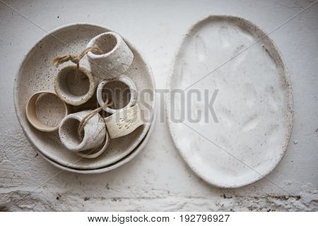 Top view on two grog clay plates with beautiful rustic napkin rings on white background