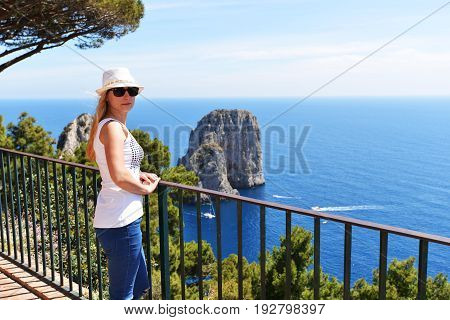 Woman in hat near fence in mountains
